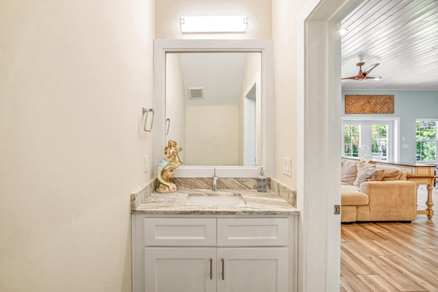 bathroom with french doors, visible vents, vanity, ensuite bath, and wood finished floors