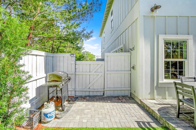 view of patio with a gate, fence, and area for grilling