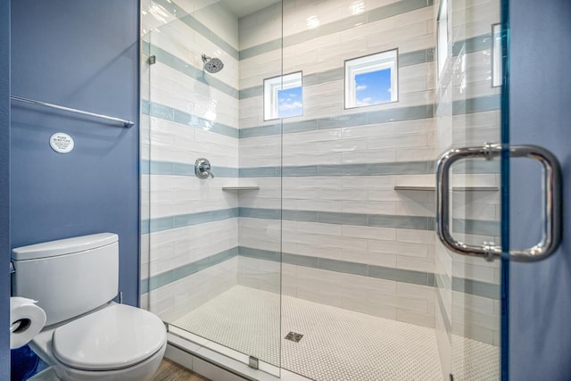 full bath featuring tiled shower and toilet