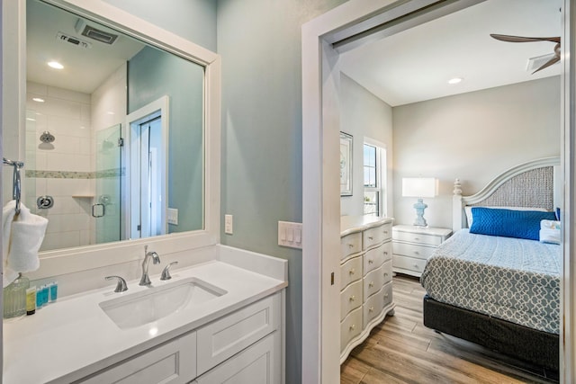 ensuite bathroom with ensuite bathroom, ceiling fan, a shower stall, vanity, and wood finished floors