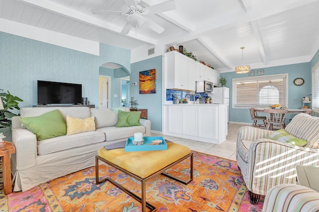 living room featuring light tile patterned floors, lofted ceiling with beams, and ceiling fan