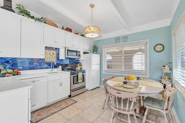 kitchen with sink, white cabinetry, appliances with stainless steel finishes, pendant lighting, and backsplash