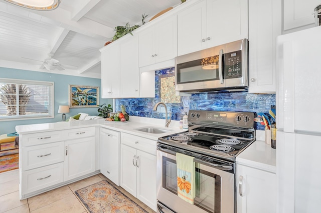 kitchen featuring appliances with stainless steel finishes, beamed ceiling, sink, white cabinets, and kitchen peninsula