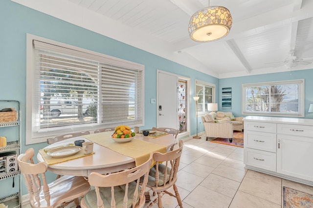 tiled dining area with lofted ceiling with beams and ceiling fan