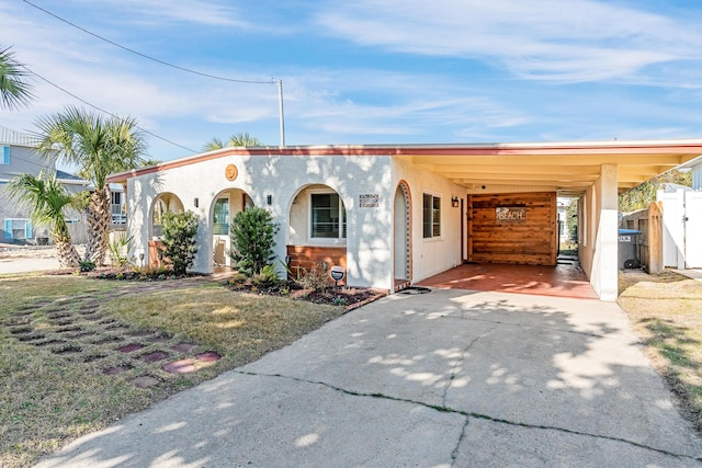 view of front of house featuring a carport and a front lawn