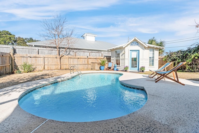 view of pool with an outbuilding and a patio area