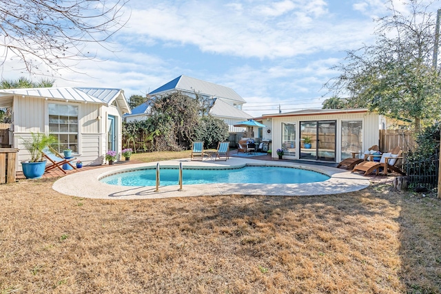 view of swimming pool with an outbuilding, a lawn, and a patio