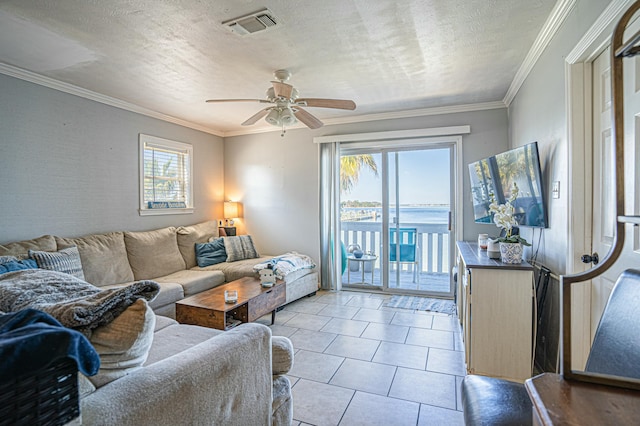 tiled living room featuring ceiling fan, ornamental molding, and a textured ceiling