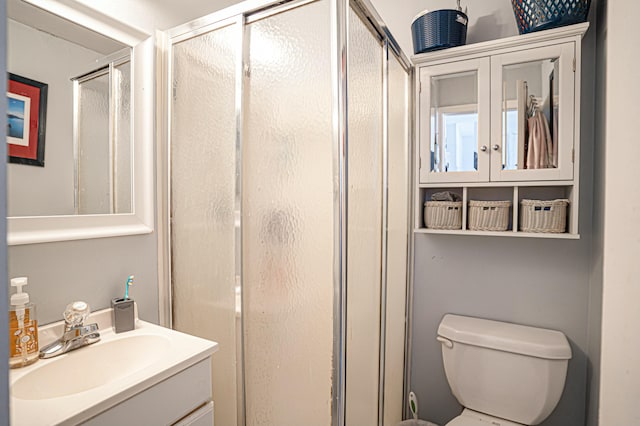 bathroom with vanity, an enclosed shower, and toilet