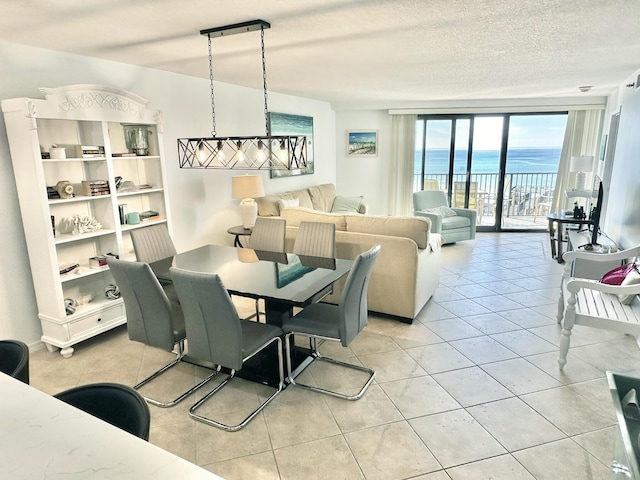 tiled dining space featuring a water view and a textured ceiling