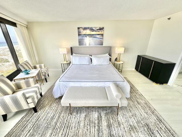 4045 Beachside One Dr # 4045, Miramar Beach, FL 32550 - bedroom with light wood-type flooring, baseboards, and a textured ceiling