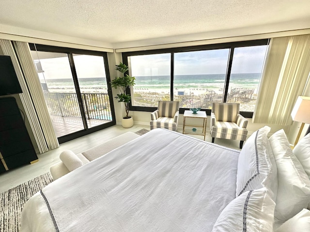4045 Beachside One Dr # 4045, Miramar Beach, FL 32550 - bedroom featuring access to exterior, wood finished floors, a textured ceiling, and a water view