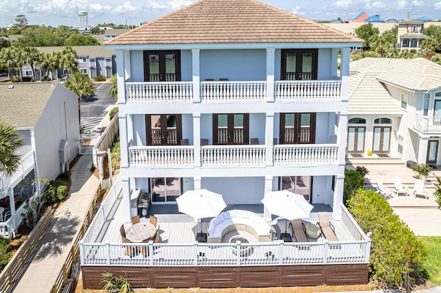 back of property with a balcony and french doors