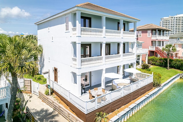 rear view of property featuring a water view and a balcony