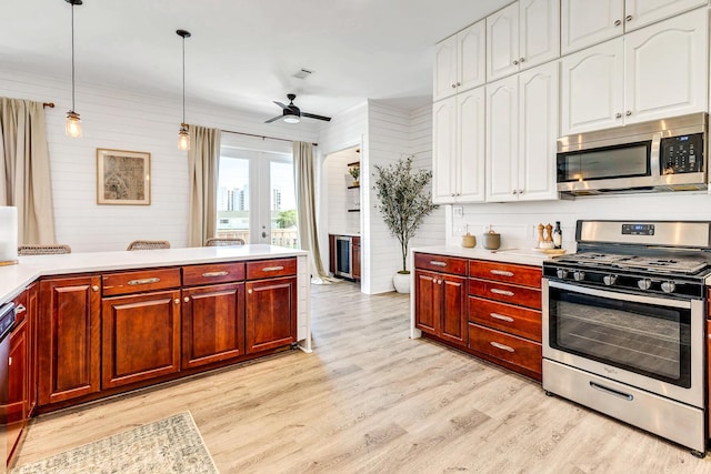 kitchen with light hardwood / wood-style flooring, hanging light fixtures, ceiling fan, stainless steel appliances, and french doors