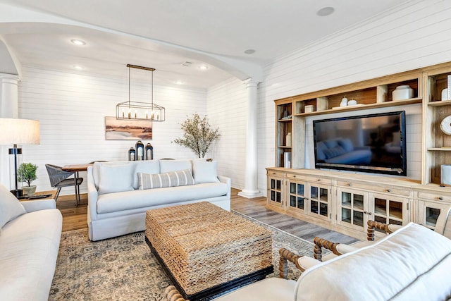 living room with dark hardwood / wood-style flooring and decorative columns