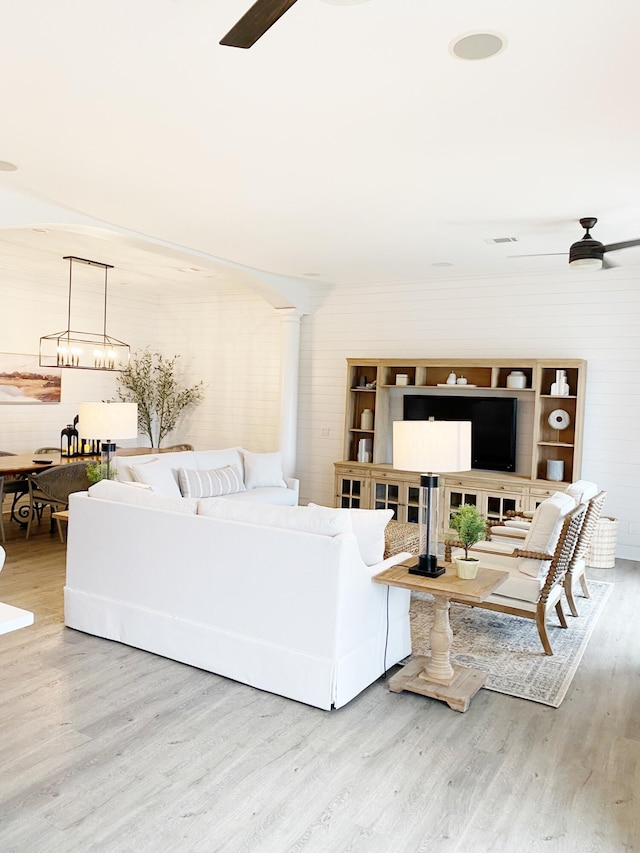 living room with wood-type flooring and ceiling fan