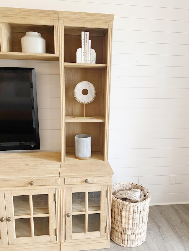 details with hardwood / wood-style floors and wood walls