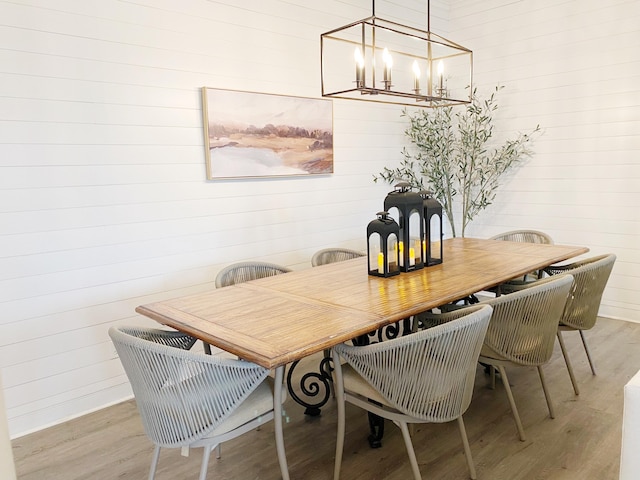 dining area with a notable chandelier and light hardwood / wood-style floors