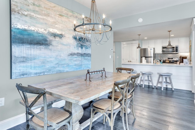 dining space with dark wood-type flooring and a notable chandelier