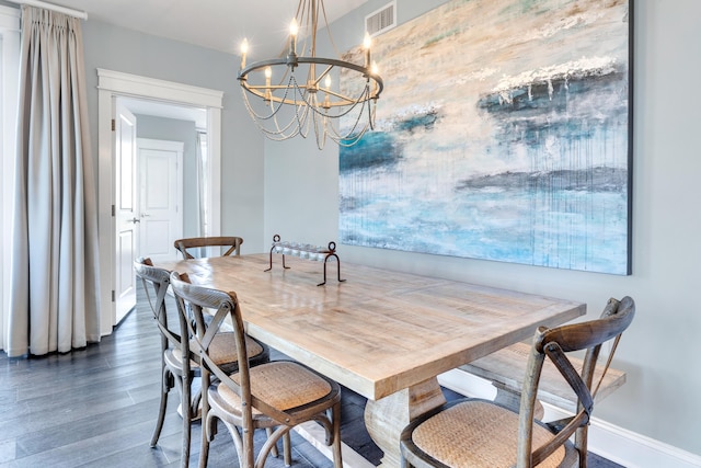 dining space featuring dark hardwood / wood-style floors and an inviting chandelier