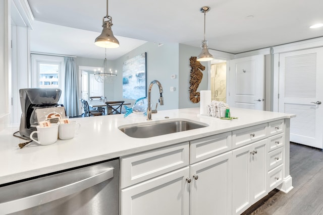 kitchen featuring dishwasher, sink, pendant lighting, and white cabinets