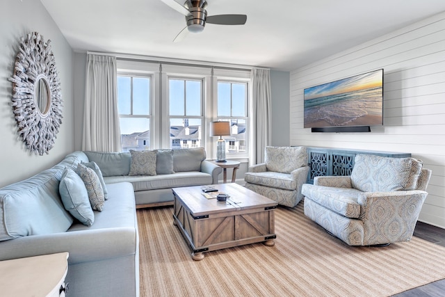 living room featuring ceiling fan, a fireplace, and light hardwood / wood-style floors