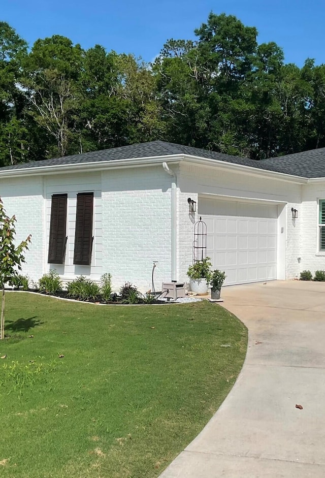 view of side of home featuring a garage and a yard