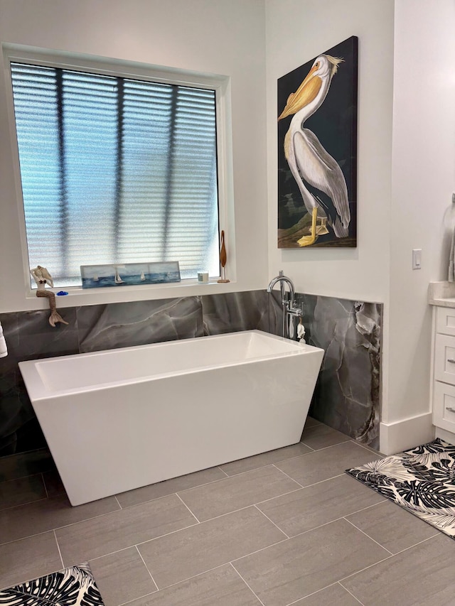 bathroom with vanity, tile walls, and a tub