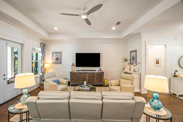 living room featuring a tray ceiling, dark hardwood / wood-style floors, and ceiling fan