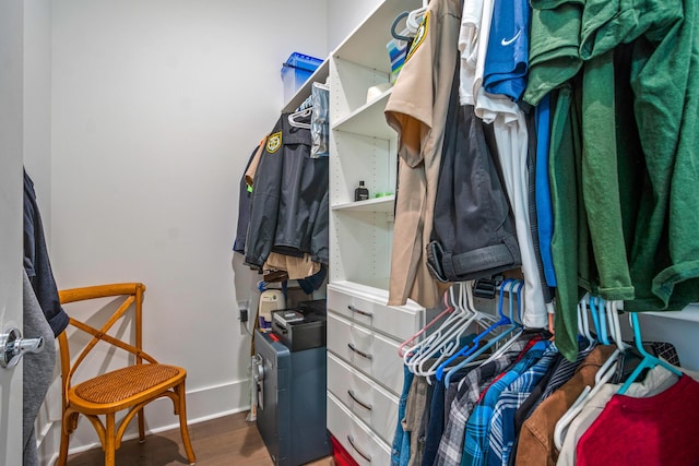 walk in closet with dark wood-type flooring