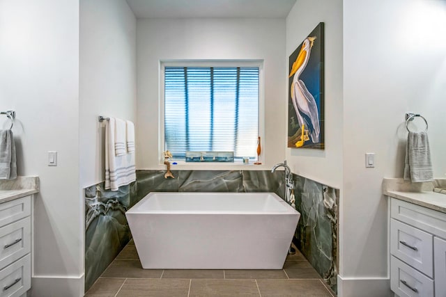 bathroom featuring vanity, a bath, and tile walls