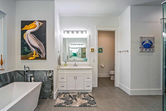 bathroom featuring vanity, toilet, and a tub