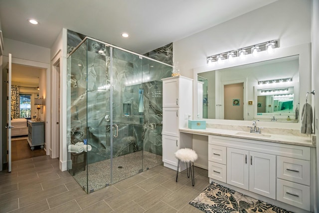 bathroom featuring vanity and a shower with door