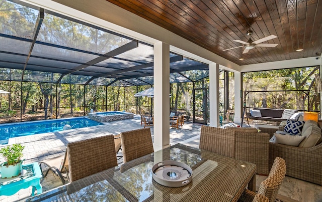 exterior space featuring a patio, an in ground hot tub, a lanai, an outdoor hangout area, and ceiling fan