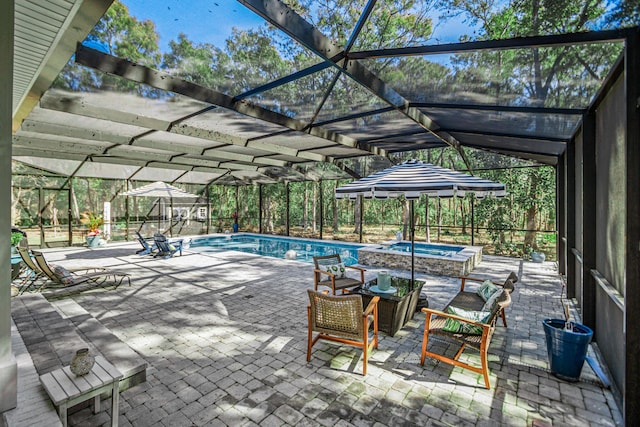 view of swimming pool with an in ground hot tub, glass enclosure, and a patio area