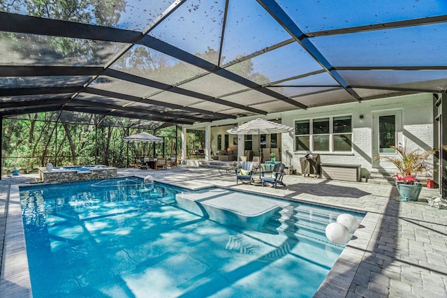 view of pool featuring a patio area, an in ground hot tub, and glass enclosure