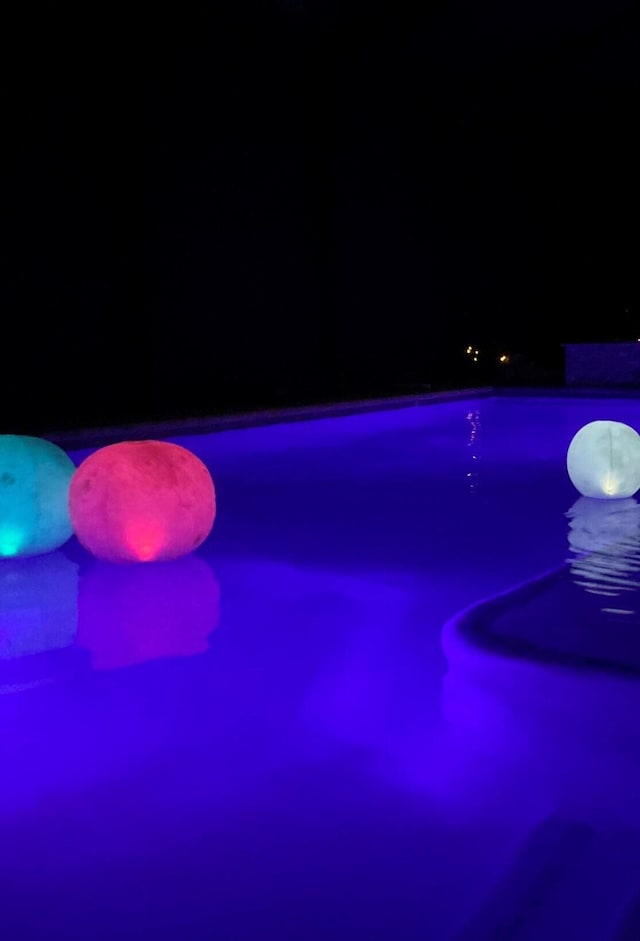 view of pool at twilight