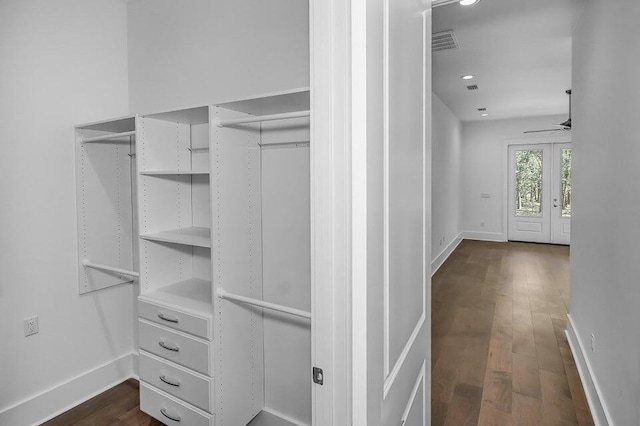 walk in closet with french doors, ceiling fan, and dark hardwood / wood-style floors