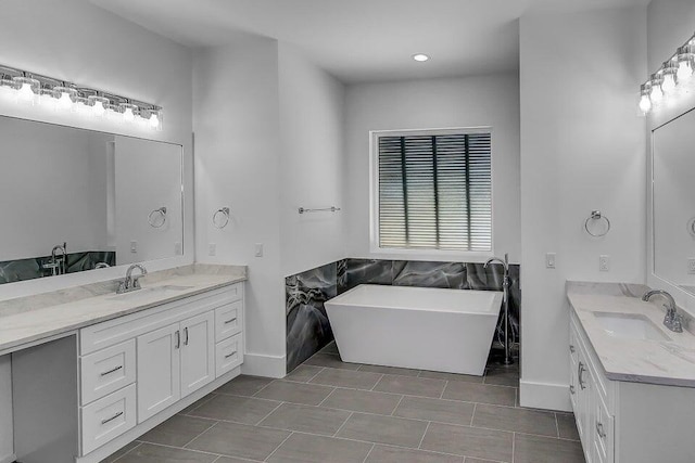 bathroom featuring tile patterned floors, vanity, and a bathing tub