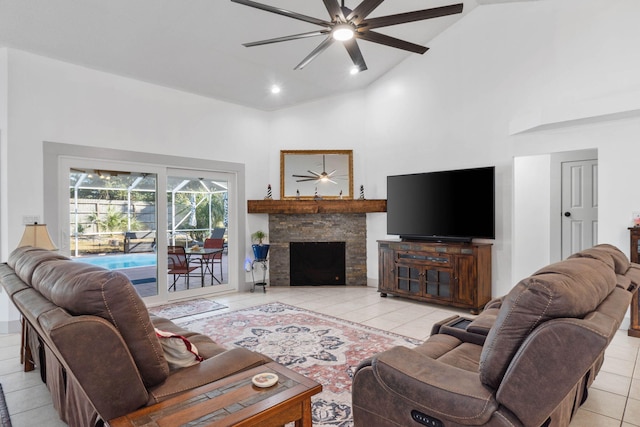 tiled living room featuring ceiling fan, a stone fireplace, and high vaulted ceiling