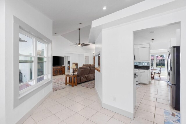 tiled living room with vaulted ceiling and ceiling fan