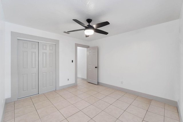 unfurnished bedroom with a closet, ceiling fan, and light tile patterned flooring