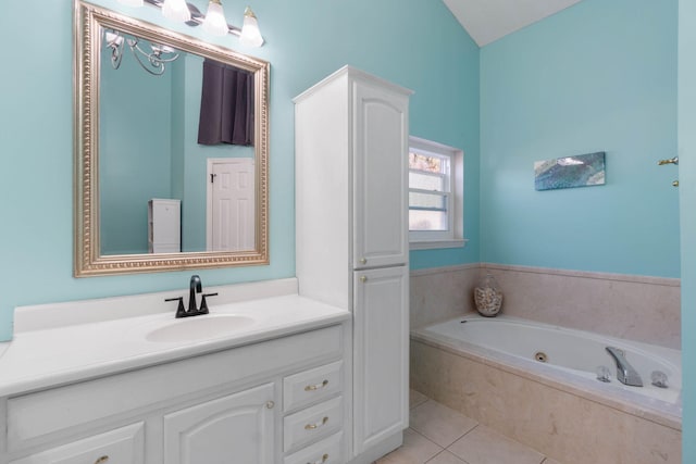 bathroom with a relaxing tiled tub, vanity, and tile patterned floors