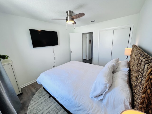 bedroom with dark hardwood / wood-style flooring, a textured ceiling, a closet, and ceiling fan