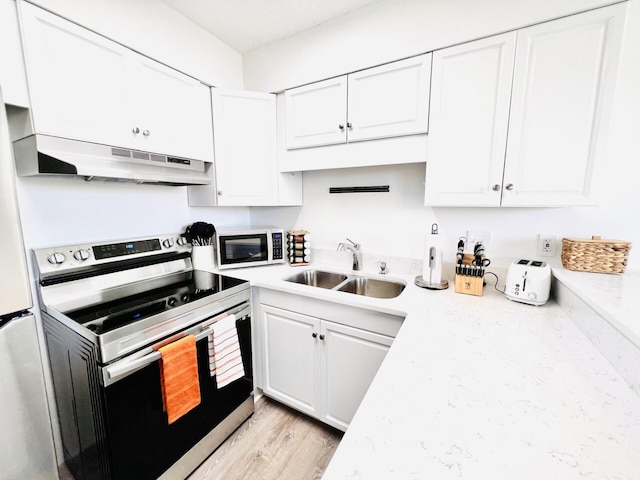 kitchen with sink, electric range, light stone countertops, light hardwood / wood-style floors, and white cabinets