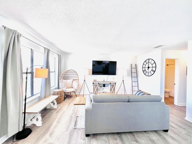 living room featuring light hardwood / wood-style floors and a textured ceiling