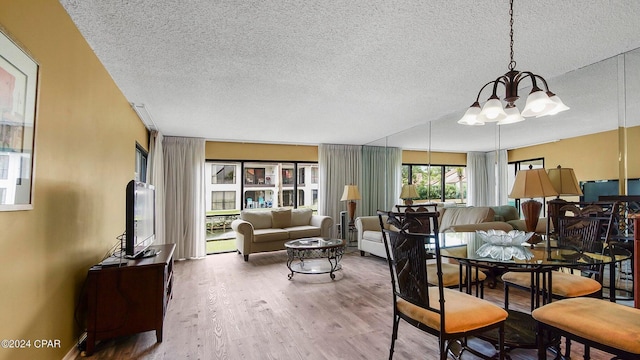 dining space with hardwood / wood-style flooring, a notable chandelier, a textured ceiling, and baseboard heating