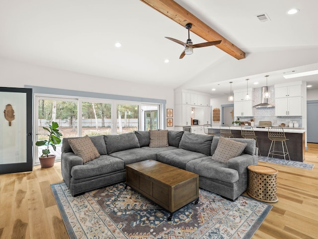 living room with lofted ceiling with beams and light hardwood / wood-style floors