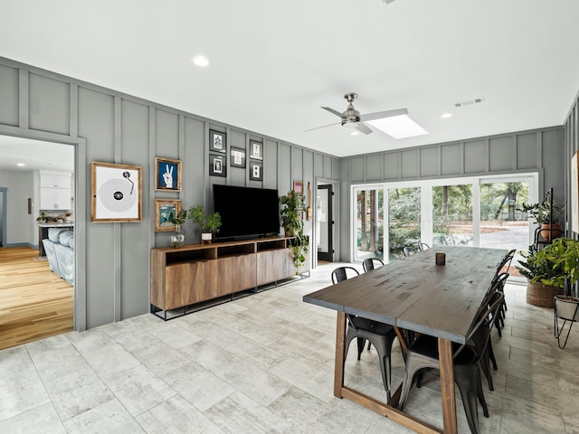 dining area featuring ceiling fan and a skylight